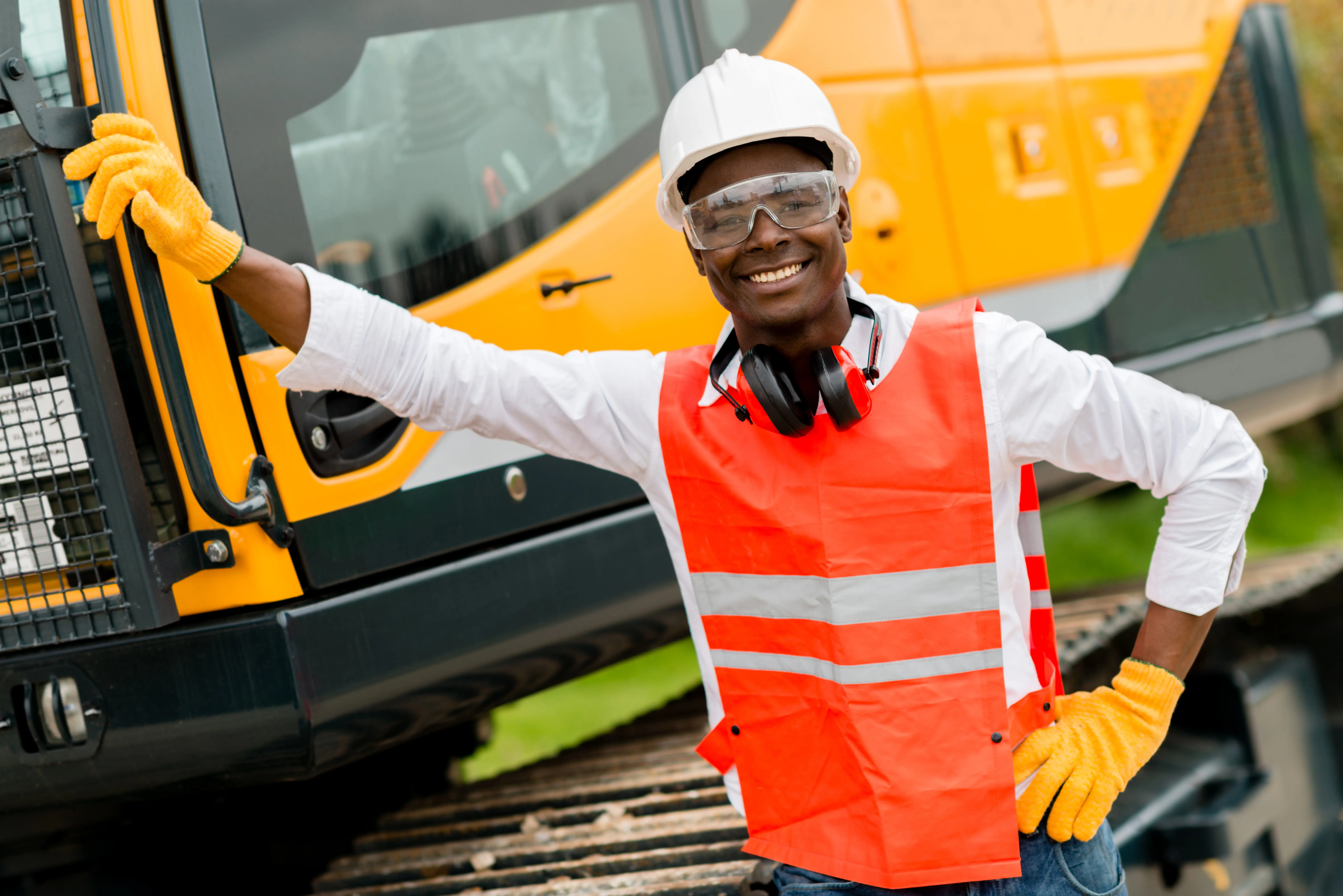 Construction worker with heavy equipment on site